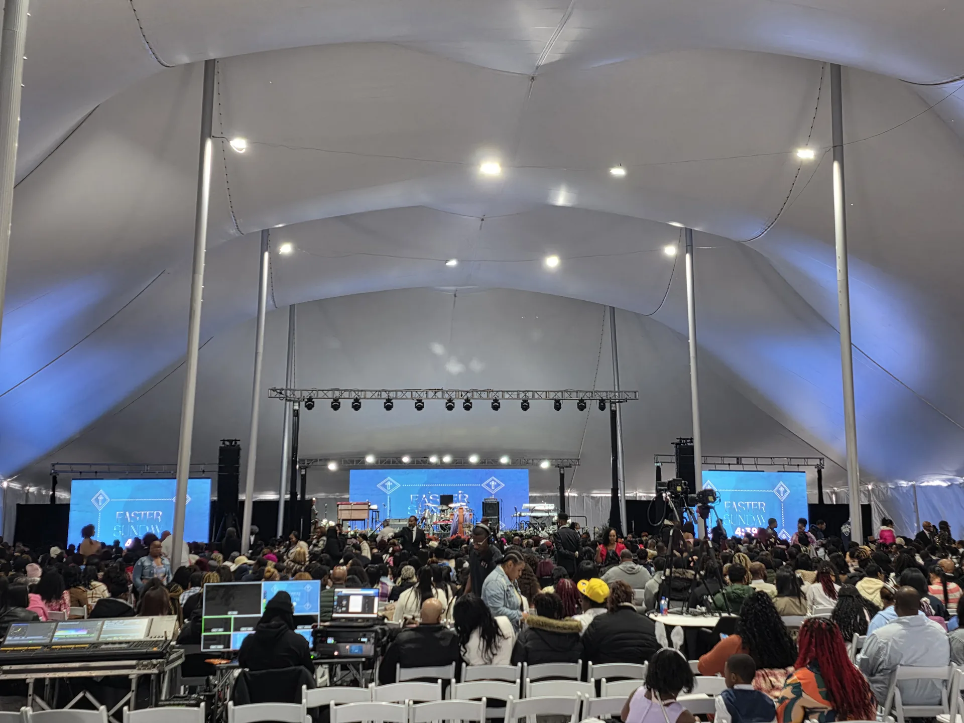 Large worship service under a high tension fabric tent with stage and LED screens